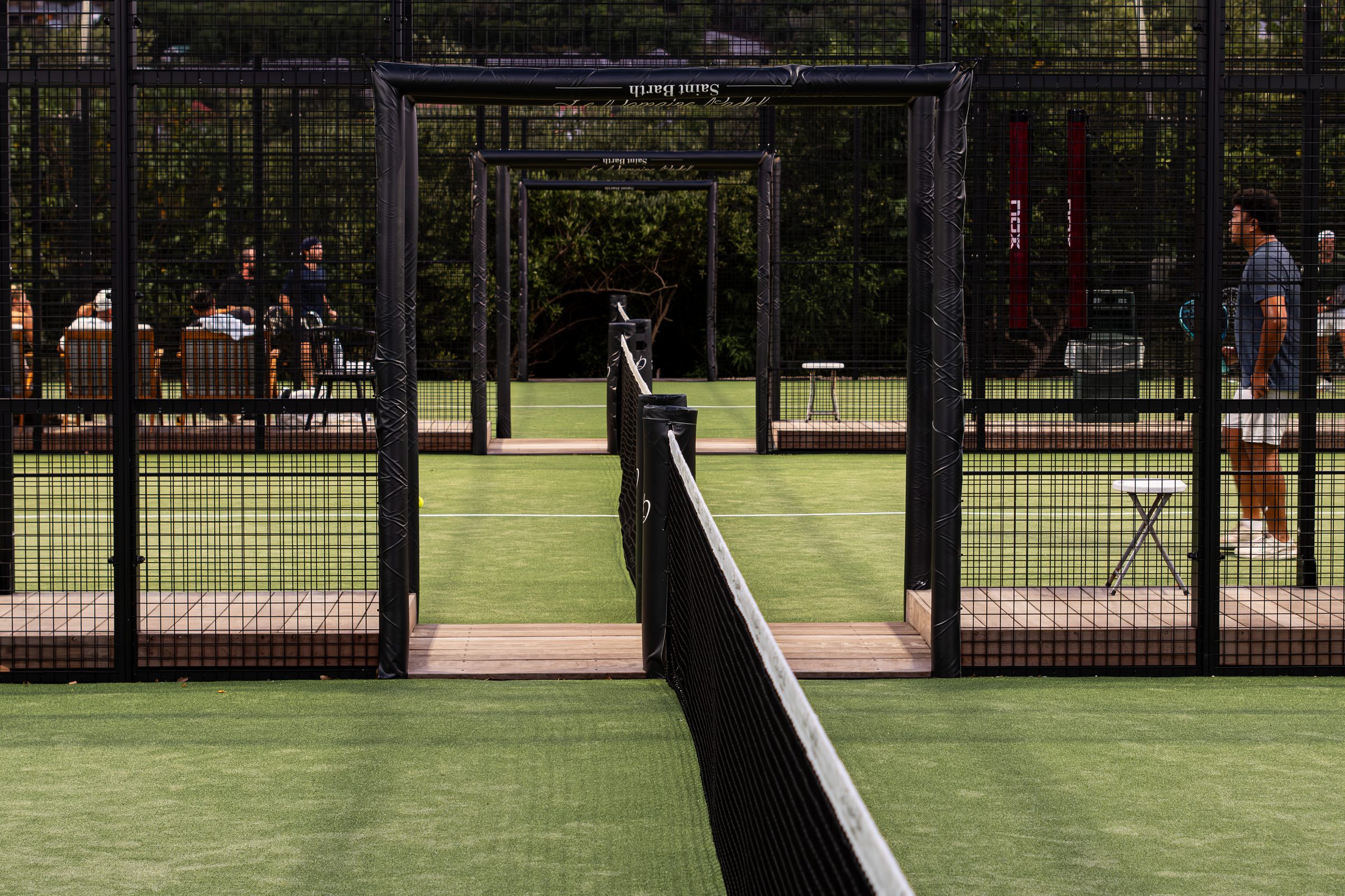 The courts of Le Domaine Padel at dusk, against the hills of Saint-Barthélemy